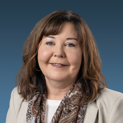A headshot of Buffy Blanton with a blue backdrop.