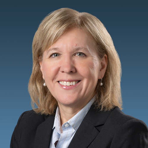 A headshot of Karen Herba with a blue backdrop.
