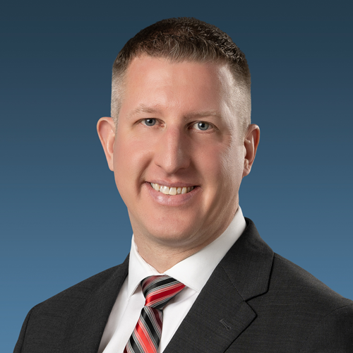 A headshot of Matt Dent with a blue backdrop.